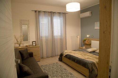 a bedroom with a bed and a chair and a mirror at Appartamento da Ciuruzzo in Trapani