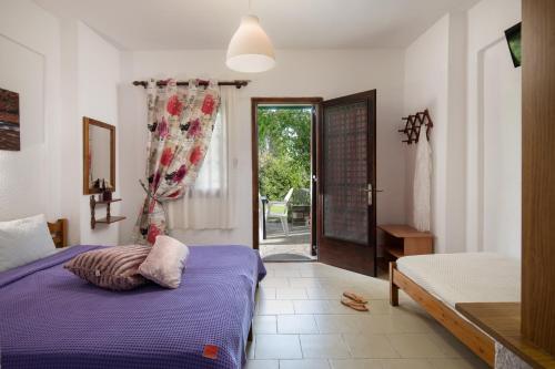 a bedroom with a bed and a door to a patio at Villa Hrisavgi in Nikiti