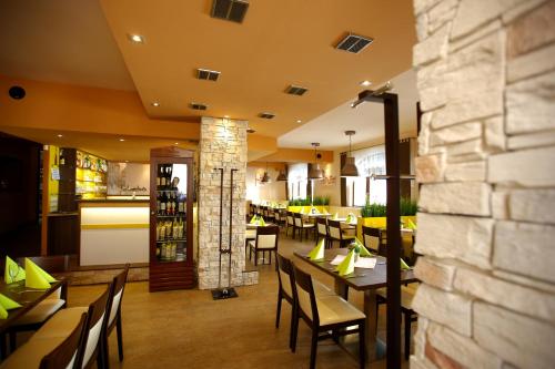 a restaurant with tables and chairs and a bar at Hotel Classic in Nový Bydžov