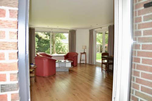 a living room with red furniture and windows at Fiddler's Hoorn in Zwaag