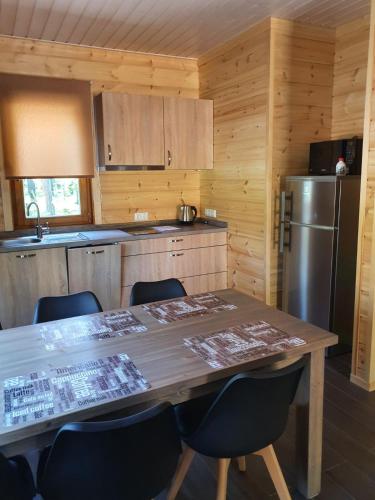 a kitchen with a wooden table with chairs and a refrigerator at Splife semi-detached cottage in Kuru