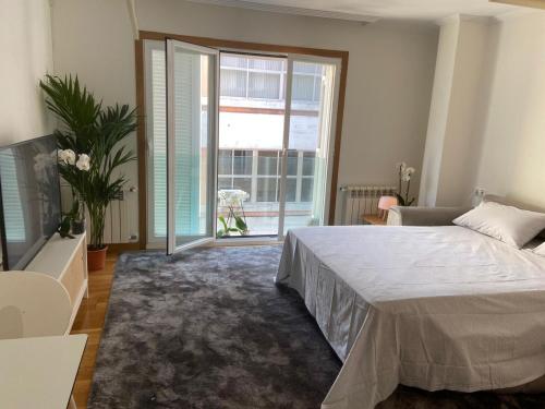 a bedroom with a bed and a large window at Estudio Parking Centro Puerta del Sol in Vigo