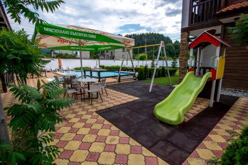 a playground with a slide and a table and a pool at Veykata Resort & Spa in Chakalarovo