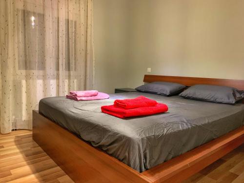 a bed with two red pillows on top of it at Petite Luxury Urban House in Tríkala