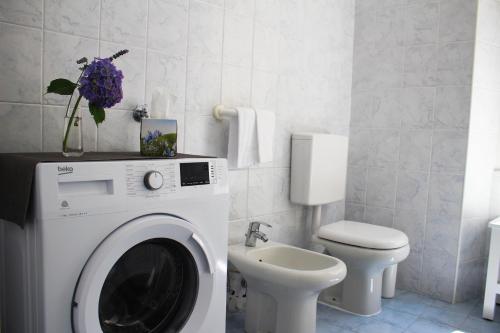 Un baño con lavadora y un inodoro. en Le Campane Studio Apartment, en Bellagio