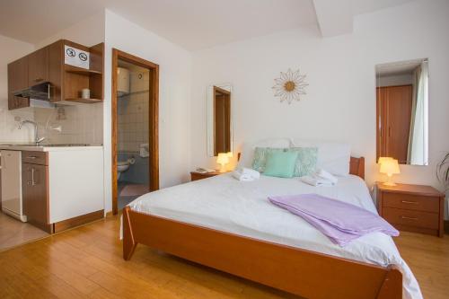 1 dormitorio con 1 cama grande y cocina en Studio Bel, en Poreč