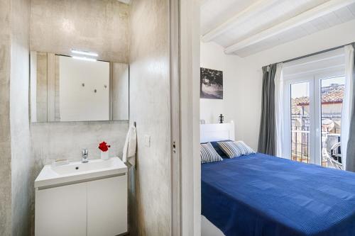 1 dormitorio con cama azul y lavamanos en CASAGIO', en Ragusa