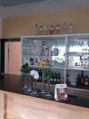a bar with wine bottles and vases on a counter at Haus S.E.E. in Marienthal