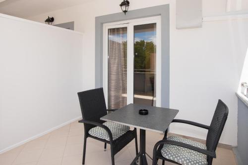 a table and chairs in a room with a window at Apartments Lovrić in Vodice
