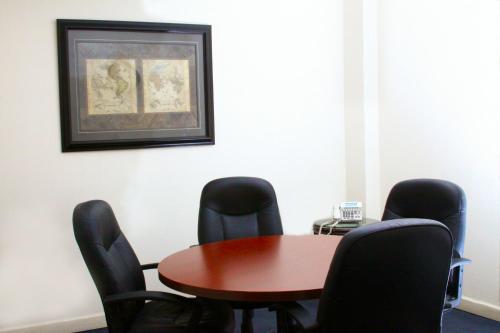 a conference room with a wooden table and black chairs at Krystal Urban Ciudad Juarez by US Consulate in Ciudad Juárez