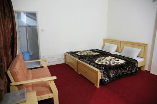 a bedroom with a bed and a chair at FR Darya E Swat Hotel in Mingāora