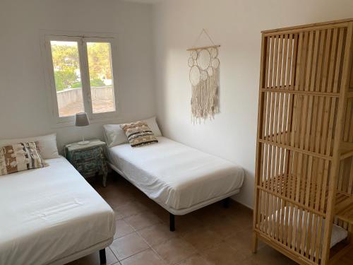 ein Schlafzimmer mit 2 Betten und einem Bücherregal in der Unterkunft Bella Paula in Es Pujols