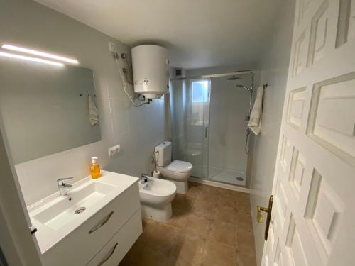 ein Badezimmer mit Waschbecken, Toilette und Dusche in der Unterkunft Bella Paula in Es Pujols