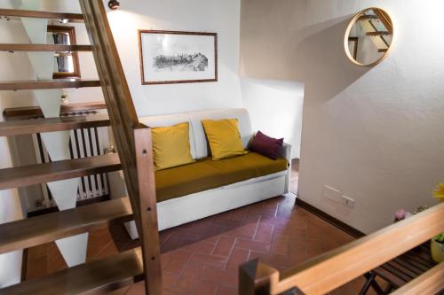 a couch with yellow pillows in a small room at La casa torre di Marcello in Certaldo
