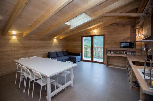 une cuisine et un salon avec une table et des chaises blanches dans l'établissement gîtes à la ferme dela le var, à Guillaumes