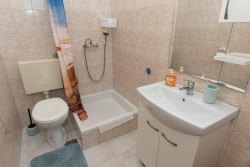 a bathroom with a toilet and a sink and a shower at Apartments Lovrić in Vodice