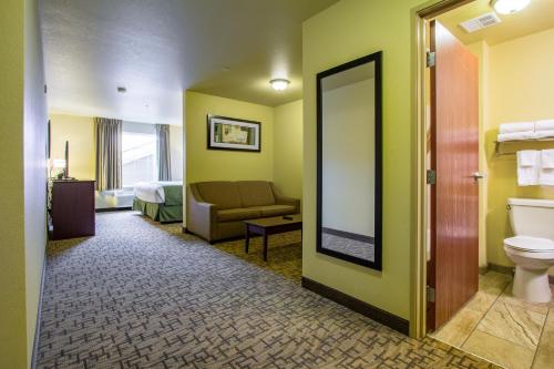 a hotel room with a toilet and a couch at Cobblestone Hotel & Suites - Orrville in Orrville