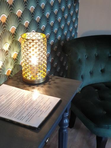 a lamp sitting on a table next to a chair at ATELIER 19 Maison d'Hôtes in Varesnes