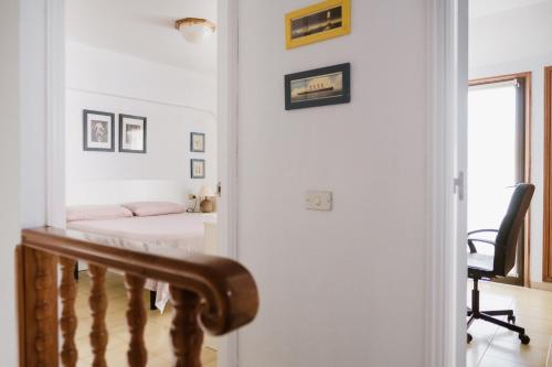 a bedroom with a bed and a staircase with a chair at Melo sur in Playa de las Americas