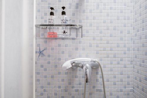 a blue tiled shower with two bottles on a shelf at Melo sur in Playa de las Americas