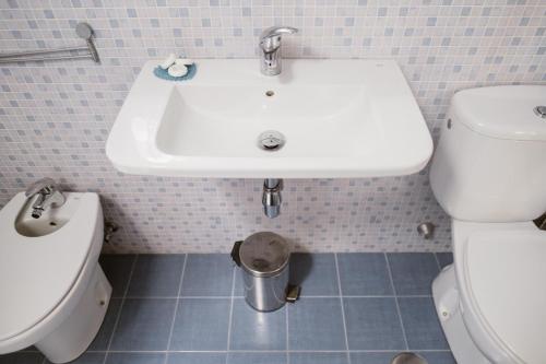 a bathroom with a white sink and a toilet at Melo sur in Playa de las Americas