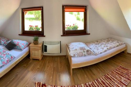 two beds in a room with two windows at Domček u Fera in Zázrivá