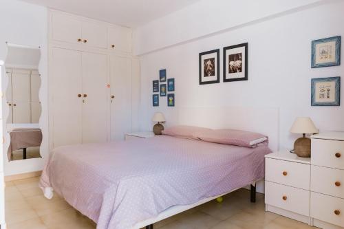 a white bedroom with a bed and white cabinets at Melo sur in Playa de las Americas