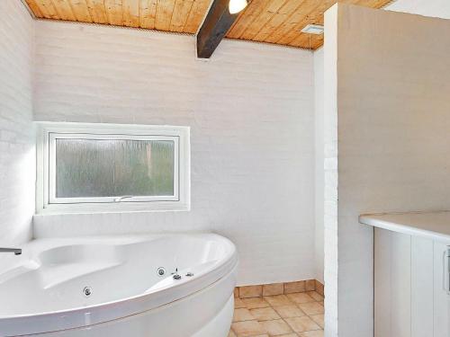 VestervigにあるSpacious Holiday Home in Vestervig with Saunaの窓付きのバスルーム(白いバスタブ付)