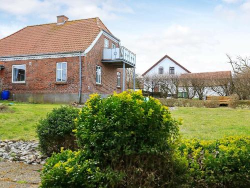 Harboørにある4 person holiday home in Lemvigのレンガ造りの家で、バルコニーが付いています。