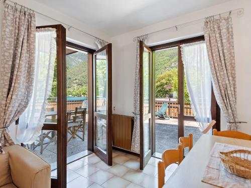 a living room with a table and chairs and sliding glass doors at In the centre of Molina di Ledro in Ledro