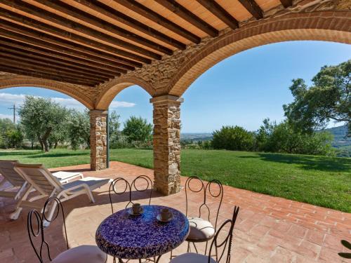 um pátio com uma mesa e cadeiras sob um pavilhão em Belvilla by OYO Casa Sugheri em Suvereto