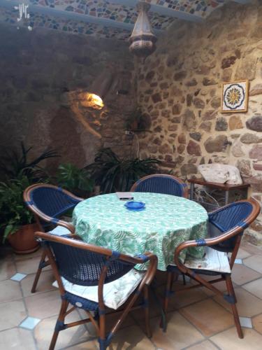 a table and chairs in a room with a stone wall at La Casa Del Teix in Eslida