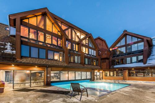 a large house with a swimming pool in front of it at The Lodge at the Mountain Village in Park City