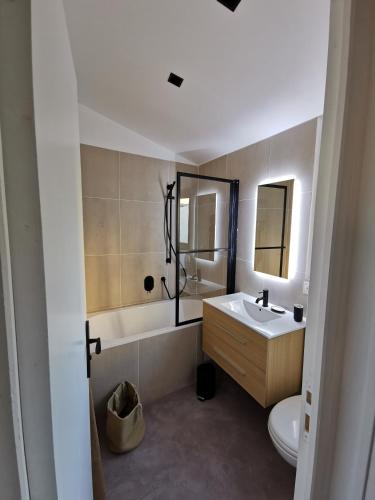 une salle de bain avec un lavabo, une baignoire et des toilettes dans l'établissement L ORANGER - Plein centre - 6 Personnes - Clim, à Cassis