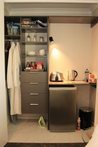 a kitchen with a stove and a shelf with pots and pans at The Birch Tree B&B in Motueka