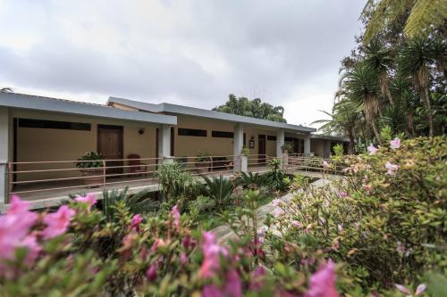 a house with pink flowers in front of it at Park Hotel in Santa Cruz Verapaz