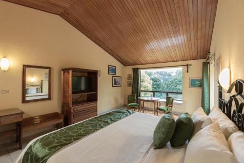 a bedroom with a large bed and a large window at Park Hotel in Santa Cruz Verapaz