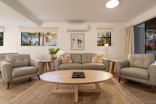 a living room with two couches and a coffee table at Gosamara Apartments in Byron Bay