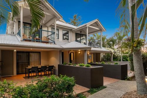 an image of a house with a table and chairs at Gosamara Apartments in Byron Bay