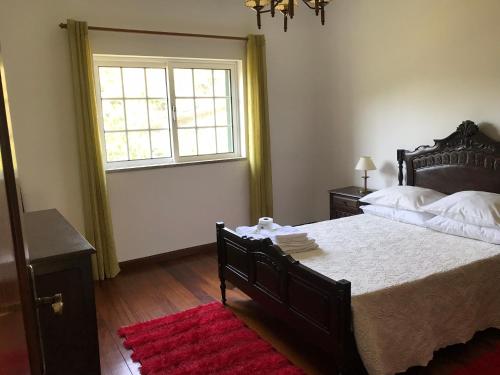 Un dormitorio con una cama grande y una ventana en Casa Largo da Igreja, en Teixeira