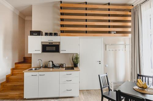 a kitchen with white cabinets and a table at BOHO HOUSE in Ustrzyki Dolne