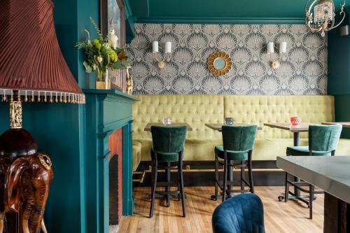 a restaurant with blue walls and green chairs at Slaymaker & Nichols Gastro House & Inn in Charlottetown