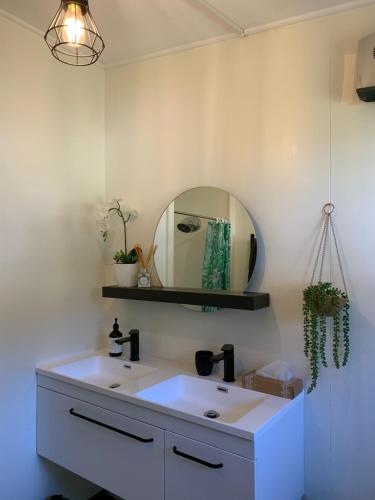 bagno con lavandino bianco e specchio di Moore St Cottage a Ohakune