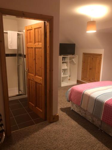 a bedroom with a bed and a sliding glass door at Skellig Port Accomodation - Sea View Rooms Ensuite in Portmagee