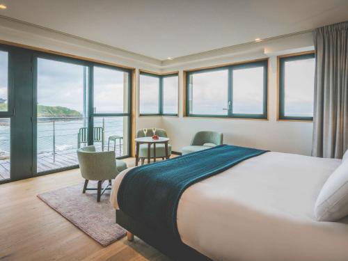 une chambre avec un lit et une vue sur l'océan dans l'établissement Sainte-Barbe Hotel & Spa Le Conquet - MGallery Collection, au Conquet
