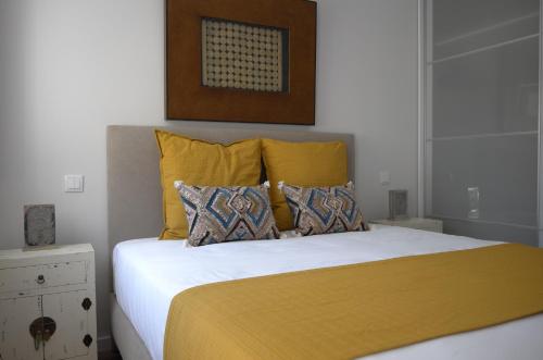 a bedroom with a bed with yellow pillows at Exotic Fusion double Suite in Lisbon