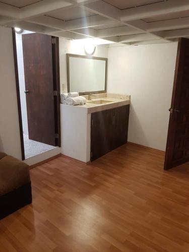 a bathroom with a sink and a mirror at Hotel Meson Mariano Matamoros in Querétaro