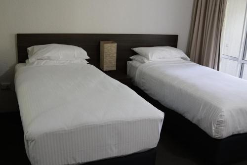 dwa łóżka siedzące obok siebie w sypialni w obiekcie Reef Resort Villas Port Douglas w mieście Port Douglas