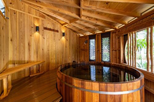una sauna de madera vacía con una gran bañera de madera en Island Breeze - Round House with BBQ - Wooden Hot Tub - Beach, en Onna