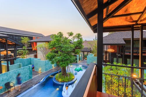 an indoor pool with a tree in the middle of a building at At Leaf Villa in Chiang Mai